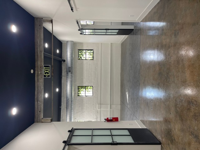 Retail space painting with polished concrete and barn doors Houston TX