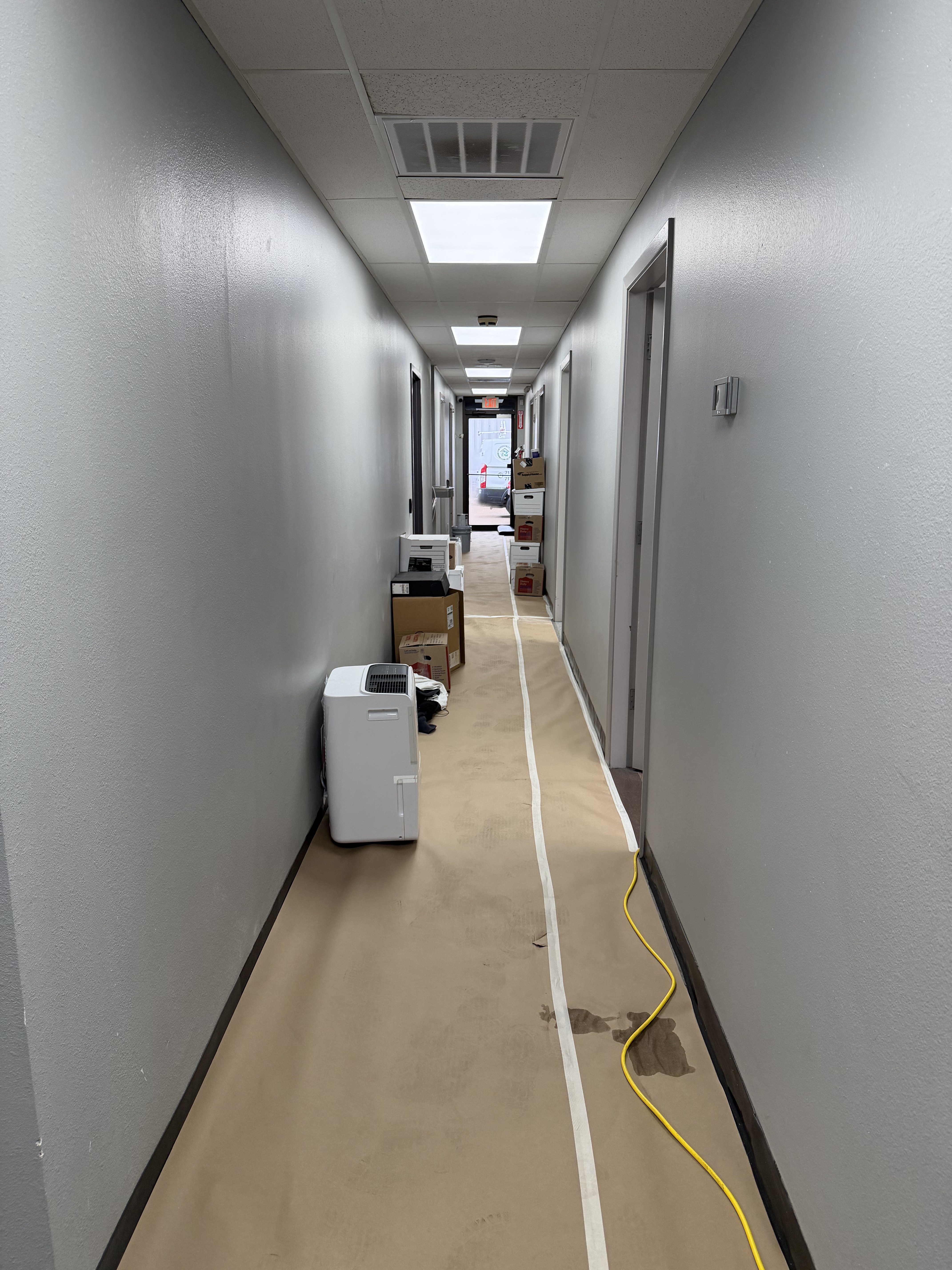 Medical facility corridor being painted with drop cloth Houston TX
