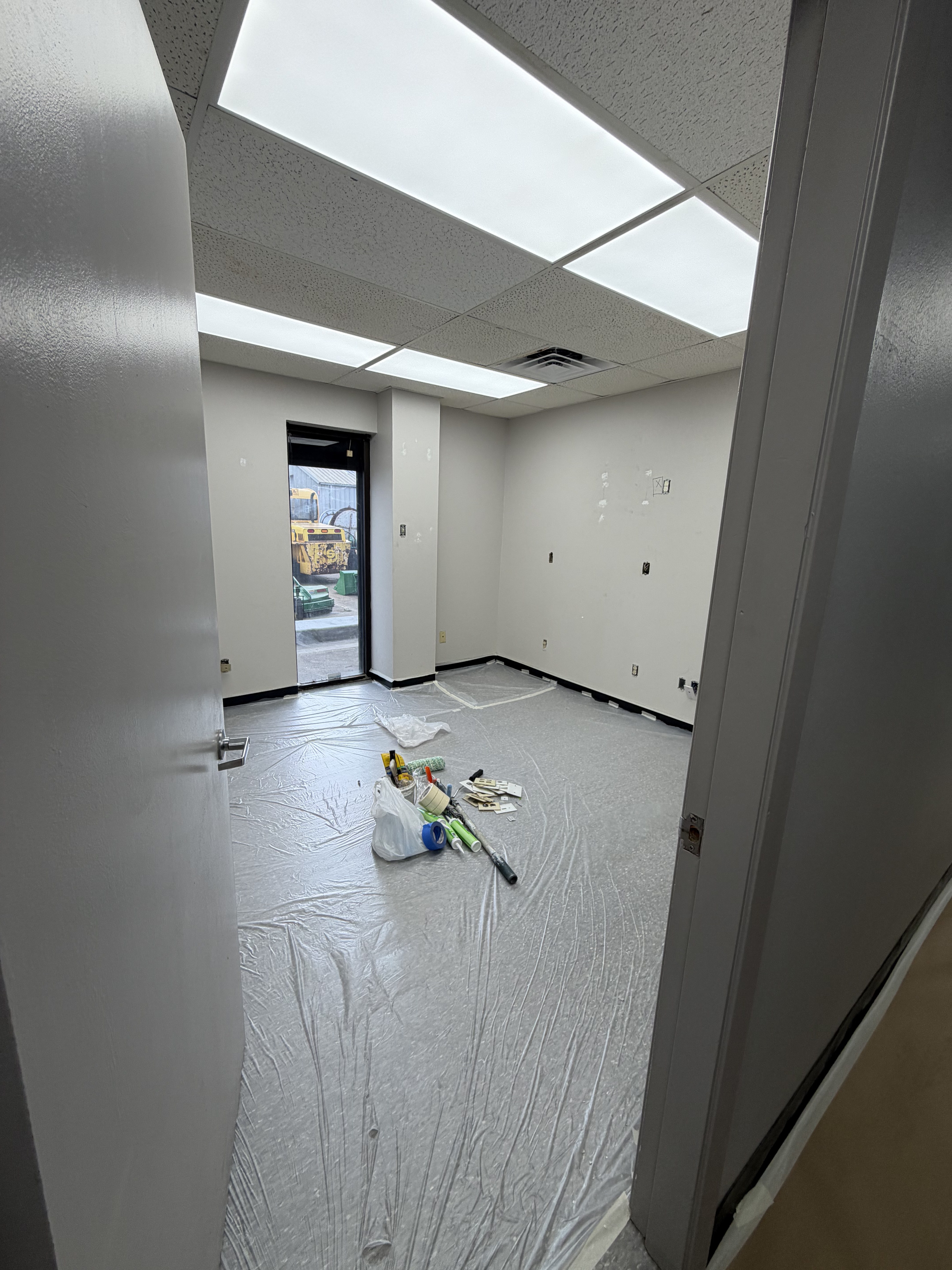 Clinic room being painted with drop cloth and tools Houston TX