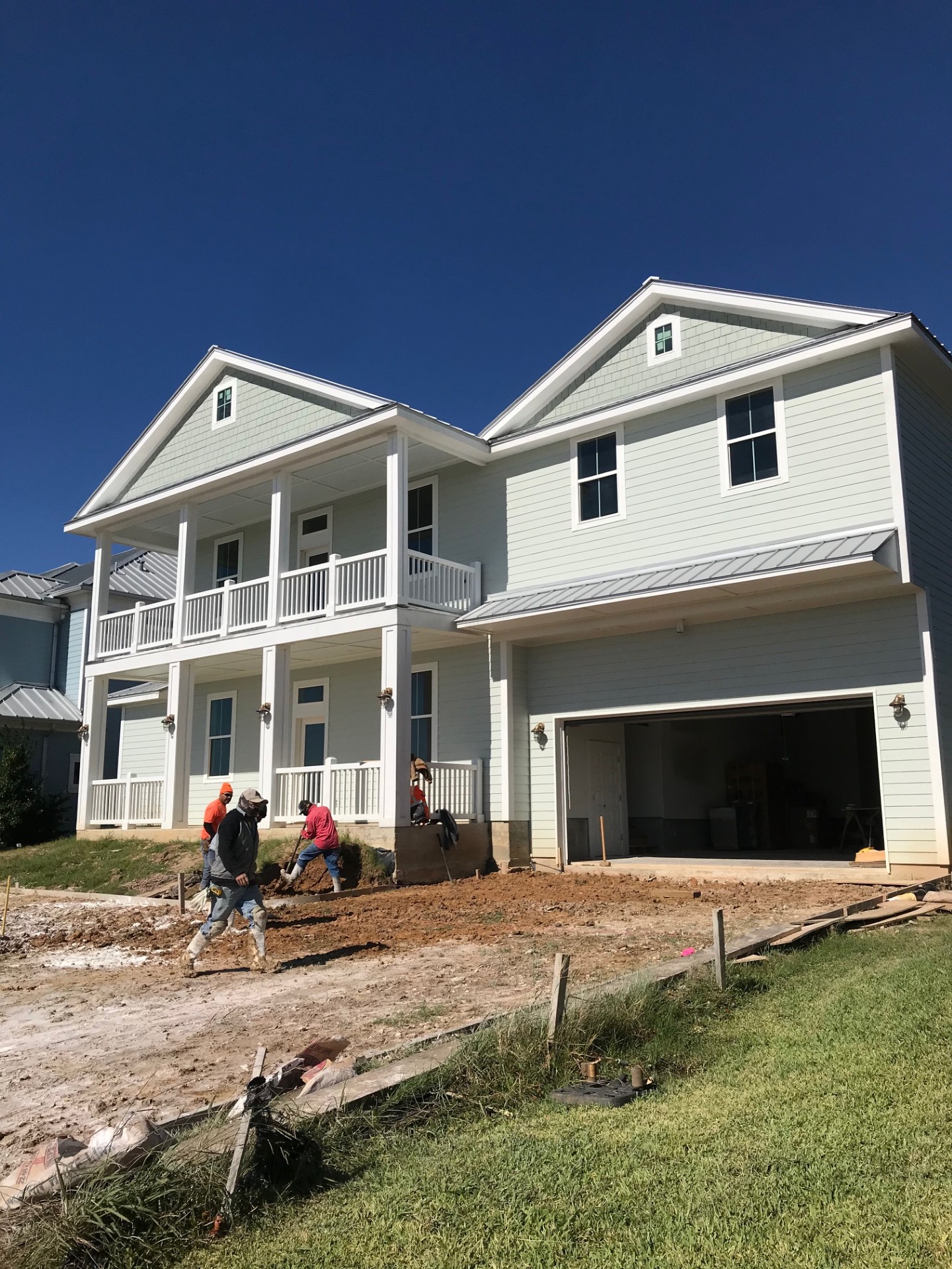 Two-story home mid-paint with crew on site